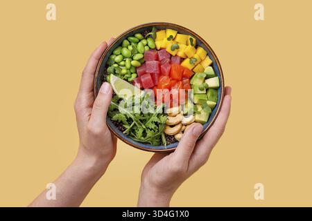 Essen, Frau, die Poke Bowl isst. Weibliche Hände, die Stäbchen halten, essen Poke Bowl mit Lachs und Avocado Stockfoto
