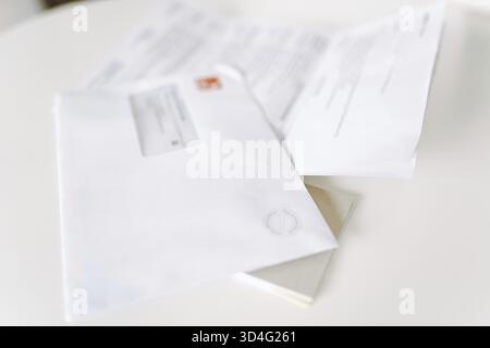Briefumschlag mit Blatt Papier, Brief auf weißem Tisch, Anzeige, Vorladung, postalische Nachricht Stockfoto