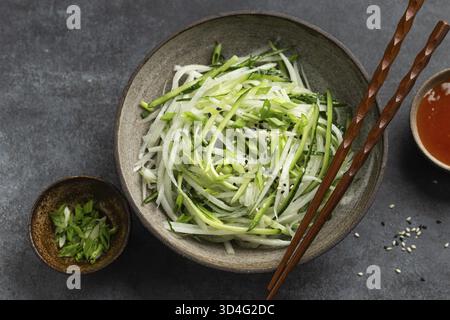 Essen, frische Gurken und Daikon Rettich Salat in Schüssel, gesunde vegane Rohkost, Blick von oben Stockfoto