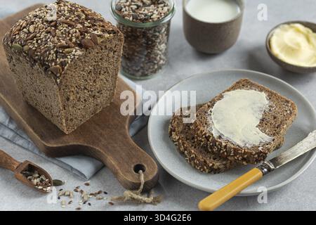 Essen, frisch gebackenes hausgemachtes Mehrkorn-Sauerteigbrot mit Butter Stockfoto