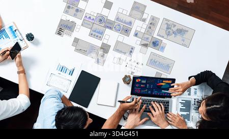 Bei einem dynamischen Geschäftstreffen werden Experten vorgestellt, die mit Laptops zusammenarbeiten, Diagramme analysieren und Strategien für datengesteuerte Lösungen diskutieren Stockfoto