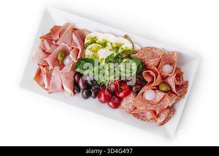 Essen, Blick von oben auf eine vielfältige Auswahl an Wurst und Käse auf einem weißen Gericht Stockfoto