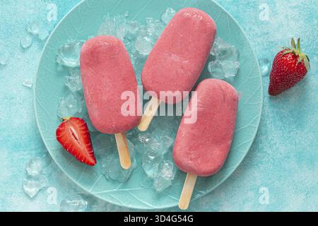 Essen, cremige Beeren, Eis-Dessert mit süßem und natürlichem Eis, Blick von oben, blauer Backplatz Stockfoto