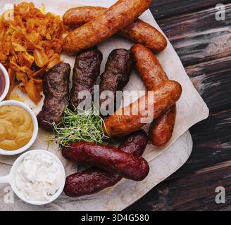 Speisen, Bier, gegrillte Würstchen mit gedünstetem Kohl und Saucen Stockfoto