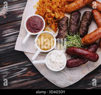 Speisen, Bier, gegrillte Würstchen mit gedünstetem Kohl und Saucen Stockfoto