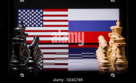 Konzeptuelles Bild des Krieges zwischen den Vereinigten Staaten und Russland mit Schachfiguren und Nationalflaggen auf einem reflektierenden Hintergrund Stockfoto
