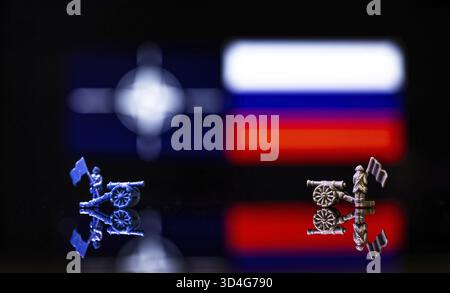 Konzeptuelles Bild des Krieges zwischen Russland und der NATO mit Spielzeugsoldaten und Nationalflaggen auf einem reflektierenden Hintergrund Stockfoto
