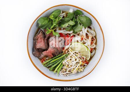 Essen, Pho Bo traditionelle Suppe mit Rindfleisch, Reisnudeln, Ingwer, Limette, Chili in einer Schüssel. Nahaufnahme. Vietnamesische und asiatische Küche Stockfoto