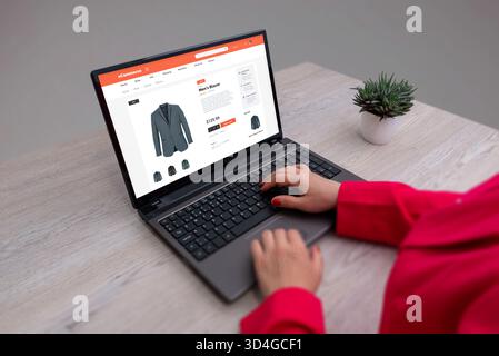 Online-Shopping für Herren-Blazer mit Laptop-, Digital Retail- und E-Commerce-Website-Konzept in einem modernen Arbeitsbereich Stockfoto