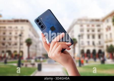 Handheld-Smartphone mit sichtbarem elektronischem Chip- und Schaltungsdesign, das Mobiltechnologie, Kommunikation, Innovation und Digital repräsentiert Stockfoto