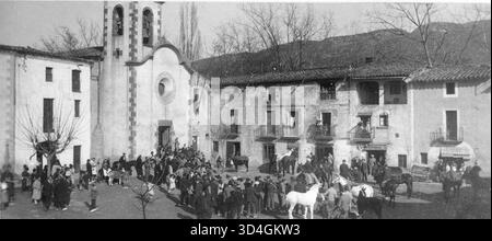 Menschen und Tiere versammelten sich vor der Kirche während des Segens am Tag des Heiligen Antonius, fotografiert von Antoni Gallardo i. Garriga im Jahr 1932. Das Bild zeigt die traditionelle religiöse Zeremonie und unterstreicht die Verbindung der Gemeinde zu Tieren. Stockfoto