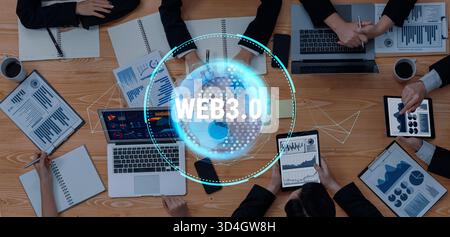 Ein vielseitiges Geschäftsteam arbeitete an Web3.0-Strategien zusammen und analysierte Daten und Trends mit Tablets und Laptops in einem dynamischen Büro Stockfoto