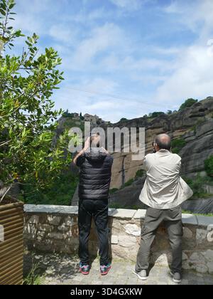 METEORA, GRIECHENLAND - 11. MAI 2025 - Touristen fotografieren das Heilige Kloster des Heiligen Nikolaus Anapafsas, UNESCO-Wahrzeichen auf dem felsigen Gipfel in Meteo Stockfoto