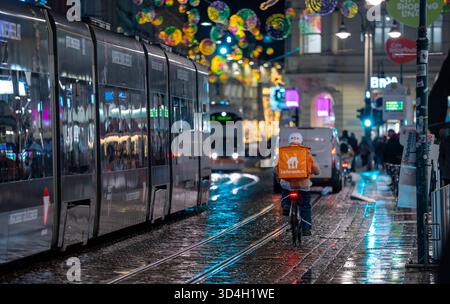 Linz, Österreich - 20. Dezember 2024: Lieferando-Lieferradfahrer transportiert am Weihnachtsabend Lebensmittelbestellung Stockfoto