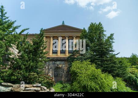 Das Philadelphia Museum of Art mit vielen Bäumen davor. Das Gebäude hat viele Fenster und viele Säulen Stockfoto