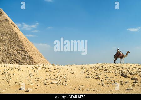 Blick auf die Seite der großen Pyramide mit einem Kamel und seinem Besitzer auf der Seite Stockfoto