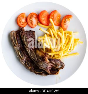 Gegrillte Rinderrippchen Churasko werden mit Pommes frites und Tomaten garniert Stockfoto