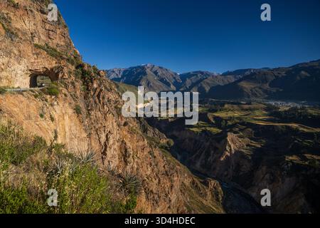 Straße, die zu einem Tunnel in einem Berg in der Nähe des Colca Canyon in Arequipa, Peru, führt, mit dramatischer Bergkulisse. Stockfoto