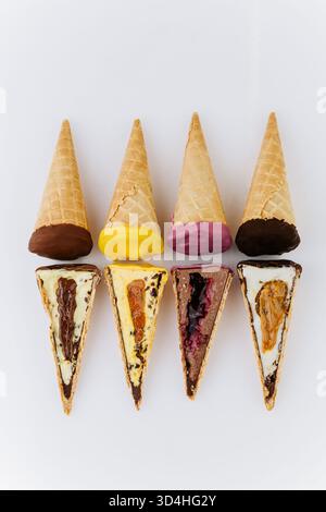 Verschiedene Eiskegel und Scheiben mit bunten Belägen auf weißem Hintergrund Stockfoto