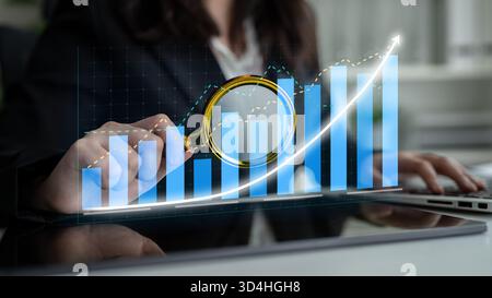 Ein Profi, der Finanzdaten mithilfe einer Lupe über Balkendiagrammen und Liniendiagrammen analysiert. Das Bild erfasst das Wesen datengesteuerter Daten Stockfoto