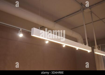 Die Beleuchtungsanordnung betont die Leuchten und architektonischen Merkmale, technische Anpassungen verbessern die Produktpräsentation durch mehrschichtige Beleuchtung und Stockfoto