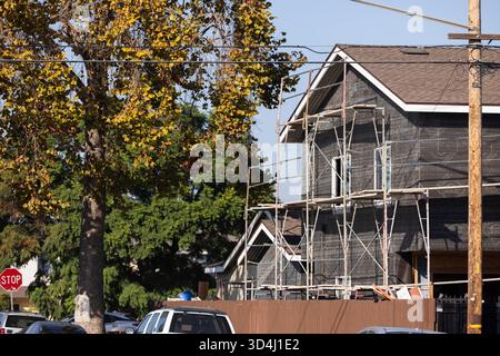 Lakewood, Kalifornien, USA - 9. November 2025: Gerüste umrahmen ein Haus, das im Außenbereich renoviert wird. Stockfoto