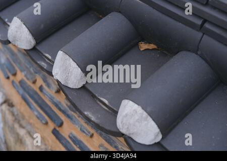 Detaillierte Nahaufnahme einer traditionellen koreanischen Ziegelmauer im frühen Winter mit Spuren des Herbstes Stockfoto