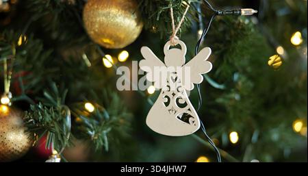 Weihnachten, Dekoration und festliche mit Engel auf Baum zu Hause für Feiern, Veranstaltungen oder Traditionen. Hintergrund, Feiertag und Tapete mit Verzierung Stockfoto