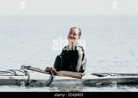 Frau Kajak Paddle Water - lächelnde Frau im Kajak auf ruhigem Wasser Stockfoto
