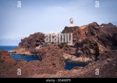 Der leuchtende Leuchtturm Punta de Teno erhebt sich hoch über felsigen Klippen und führt die Seefahrer in die Nähe der Küste Teneriffas, Spanien Stockfoto