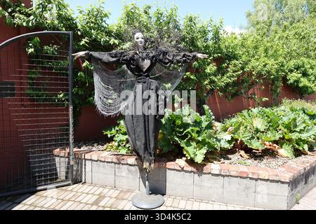Gruselige Vogelscheuchen-Figur in schwarzem Kleid im Garten Stockfoto