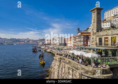 Ribeira Promenade mit Cafés, Booten und historischen Häusern am Fluss Douro, Porto, Portugal Stockfoto