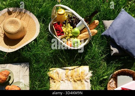 Das Hotel bietet ein romantisches Picknick mit Korb voller leckerer Speisen und Getränke auf dem Gras im Park Stockfoto