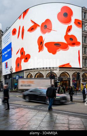 London, Großbritannien. November 2025. Das nächtliche Herbstwetter bedeutet, dass viele Passanten nicht einmal nach oben schauen, geschweige denn pausieren, leider - die Piccadilly Lights in London werden am Tag des Waffenstillstands, dem 11. November, angehalten, wenn der Bildschirm, der von Ocean Outdoor für Landsec betrieben wird, von der Royal British Legion übernommen wird. Es ist ein Highlight des zweiminütigen Schweigens und gibt den Menschen einen Moment, innezuhalten und nachzudenken, während die Nation zusammenkommt, um sich an jene zu erinnern, die so viel für die Freiheit gegeben haben, die wir heute genießen. Guy Bell/Alamy Live News Stockfoto
