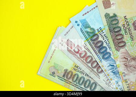 Vietnamesische Dong-Geldscheine in großer Höhe in der Nähe auf Gelb. Finanz- und Bankkonzept Stockfoto