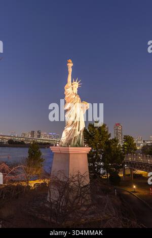 Tokio, Japan - 14. März 2025: Erleuchtete Odaiba Freiheitsstatue eine Nachbildung der Originalstatue in New York in der Nähe der Regenbogenbrücke mit Blick auf die Bucht von Tokio, Japan Stockfoto