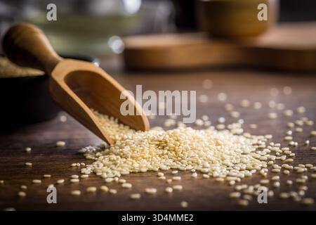 Gebratene Sesamsamen in einer Schaufel auf einem Holztisch. Stockfoto
