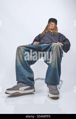 Junger Mann mit Dreadlocks, der Streetwear-Mode trägt. Stockfoto