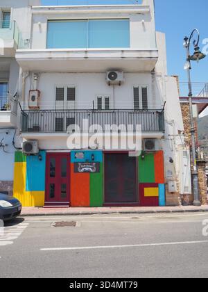 Farbenfrohe Storefront in Taormina, Sizilien, mit hell bemalten Paneelen, traditionellem Balkon, mediterraner Architektur und Straßenatmosphäre Stockfoto
