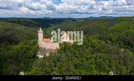 Medieval castle of Kokorin standing alone in the czech landscape surrounded by deep forest, stunning aerial shot from above. Stockfoto
