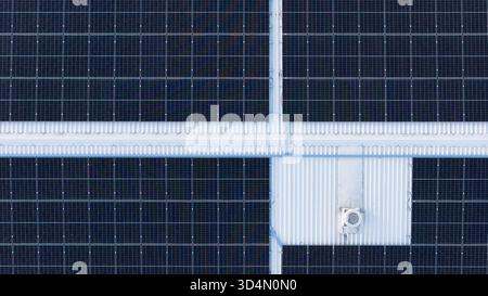 Top-down-Drohnenfoto von Solarenergie-Panels auf Industriedach, geometrisches Muster, das moderne grüne Technologie repräsentiert Stockfoto