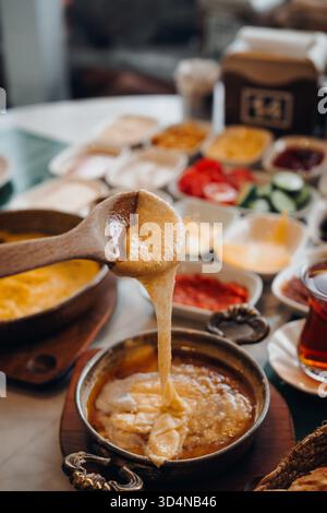 Nahaufnahme eines traditionellen türkischen Frühstückstisches mit Kuymak, einem regionalen Gericht aus Maismehl, Butter und geschmolzenem Käse, serviert mit verschiedenen Gerichten Stockfoto