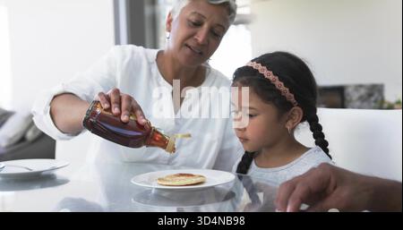 Das Kind mit Stirnband beobachtet den Pfannkuchen Stockfoto