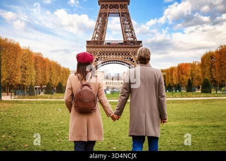 Reisekonzept mit einem romantischen Paar, das vor dem Eiffelturm in Paris, Frankreich, steht Stockfoto