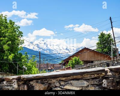 Blauer Himmel über Haus in Mestia Stadt und Bergen in Samegrelo-Zemo Svaneti Provinz in Georgien an sonnigen Sommertagen Stockfoto