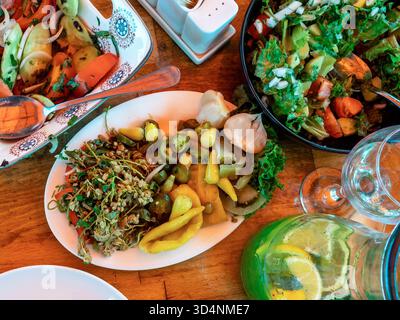 Blick von oben auf traditionelle georgianische Gurken und Salate auf Holztisch im Fischmarkt-Café im Freien in Batumi City, Georgia Stockfoto