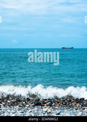 Blick auf das Wasser des Schwarzen Meeres mit Schiff vom Kiesstrand in Batumi Stockfoto
