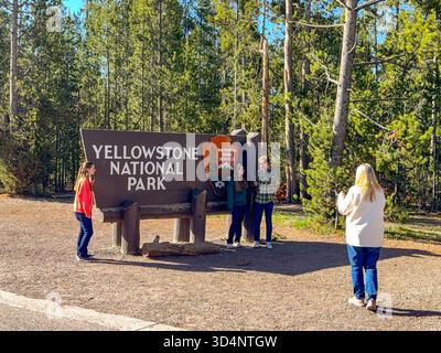 West Yellowstone, Montana, USA - 30. Mai 2025: Touristen posieren für Fotos vor dem Schild am Westeingang des Yellowstone-Nationalparks Stockfoto