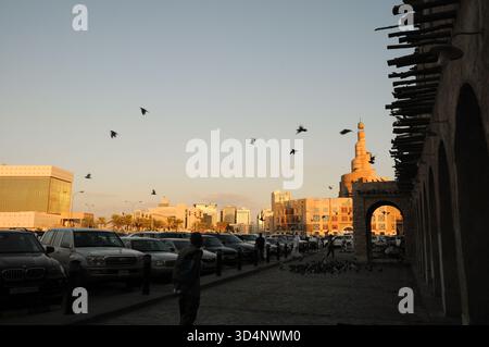 Tauben fliegen zwischen Gebäuden des wiederaufgebauten alten Souks, Souq Waqif, Doha, Katar, Arabisch... Stockfoto