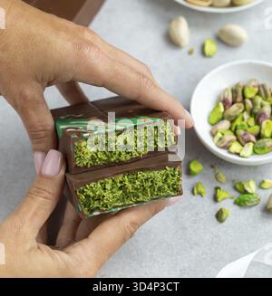 Essen, köstliche Pistazien und Kataifi Dubai Schokoladenriegel in Frauenhänden Stockfoto